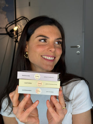 Strahlende Frau hält drei Sylwa-Magnetwimpern-Boxen in den Händen – Modelle Dubai, Barcelona und Manila. Perfekt für verschiedene Looks von natürlichem No-Makeup-Makeup bis hin zu dramatischem Cat-Eye. Die veganen, wiederverwendbaren Wimpern bieten Volumen und Schwung ohne Wimpernkleber.